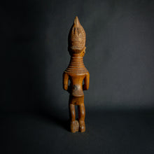 Load image into Gallery viewer, Hand-carved wooden statue of a mother holding a child, embodying fertility and continuity in African culture.