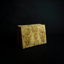 Load image into Gallery viewer, A close-up image of a beautiful box made of animal skin with intricate designs inspired by Senufo masks and animals. The box is adorned with rich patterns and textures, and has a unique and rustic feel. It can be used for storage or as a decorative piece in any home.