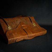 Load image into Gallery viewer, Vintage brown embossed leather briefcase with gold-tone hardware on a dark background.