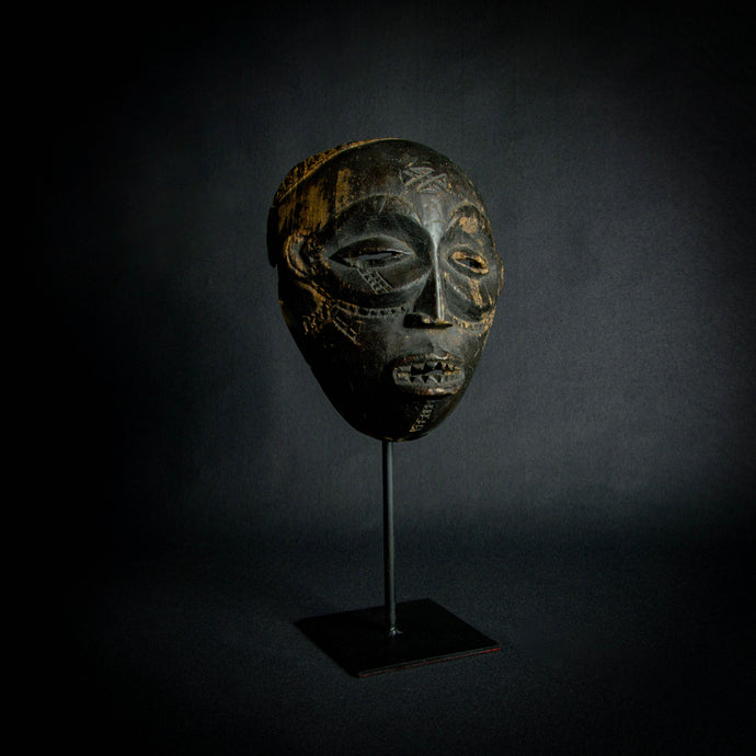 Chokwe Mask with Traditional Forehead Sign – Exploring Chokwe Artistry, a symbol of Chokwe culture and craftsmanship, featuring visible teeth and scarification.