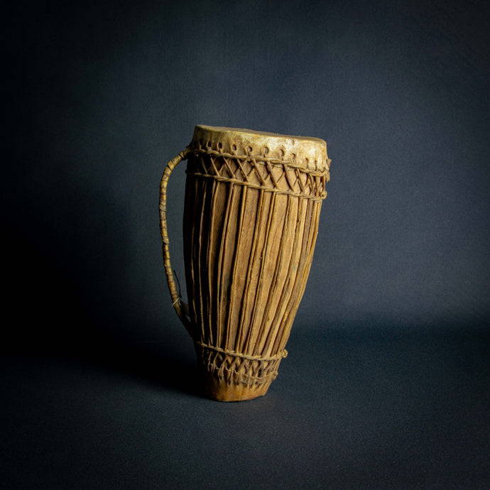 Traditional African hand drum with a tapered wooden body, intricate ropework, and a weathered hide head, evoking the spirit of African music.