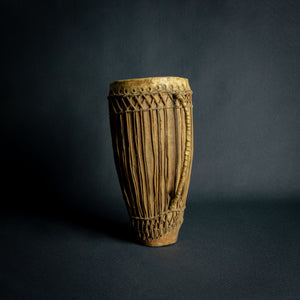 Traditional African hand drum with a tapered wooden body, intricate ropework, and a weathered hide head, evoking the spirit of African music.