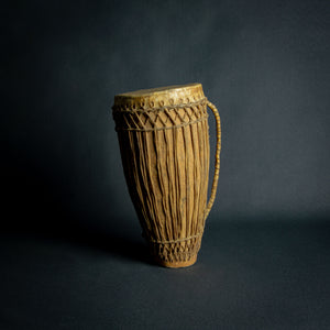 Traditional African hand drum with a tapered wooden body, intricate ropework, and a weathered hide head, evoking the spirit of African music.