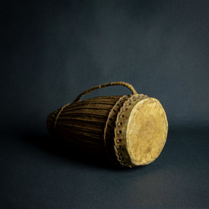 Traditional African hand drum with a tapered wooden body, intricate ropework, and a weathered hide head, evoking the spirit of African music.