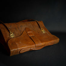 Load image into Gallery viewer, Vintage brown embossed leather briefcase with gold-tone hardware on a dark background.
