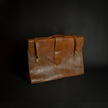 Load image into Gallery viewer, Vintage brown embossed leather briefcase with gold-tone hardware on a dark background.
