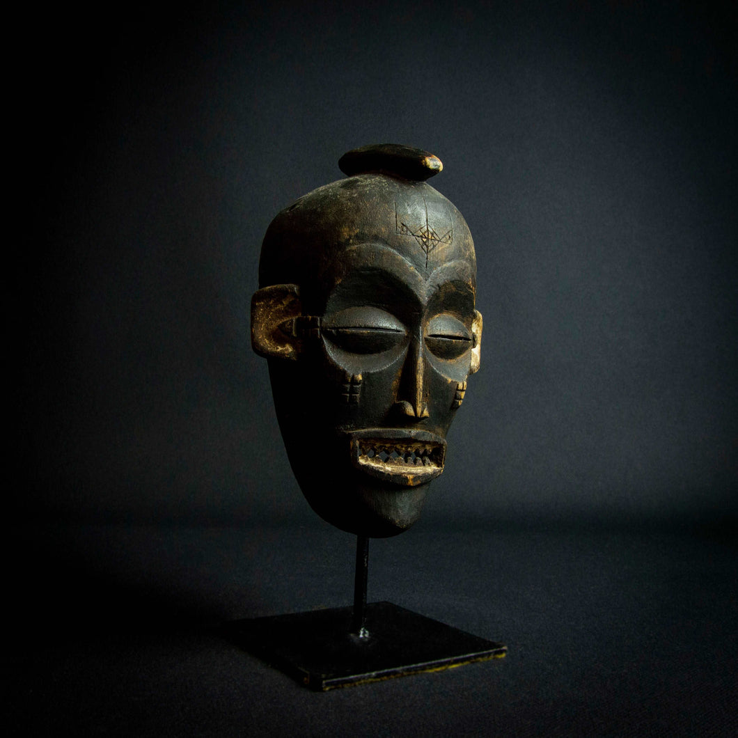 Chokwe Pwo Mask from Angola, Africa representing a beautiful woman with scarifications on her face, which symbolize beauty and status in the community.