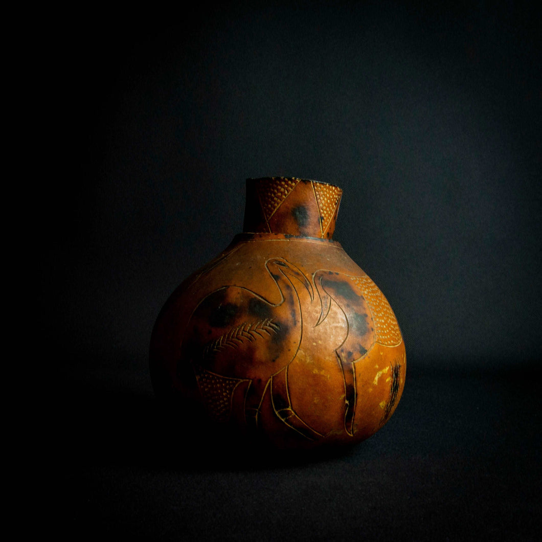 Vintage handcrafted calabash gourd with animal-inspired engravings