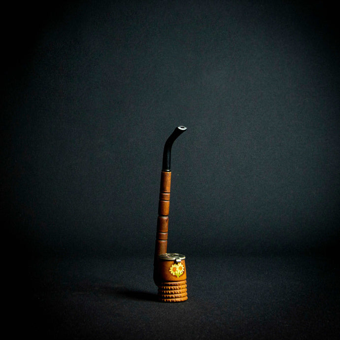 A wooden pipe with a German-style design and flower decoration on the stove, featuring a metal cover with a secure closure.