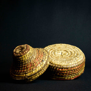 Handmade African raffia box adorned with colorful patterns and designs, perfect for storing small items or as a decorative accent piece.