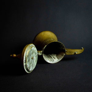 Antique Islamic teapot made of brass and copper with intricate designs and engravings on the exterior.